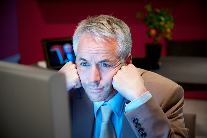 IT recruiter looking surprised at a computer screen in an office setting.