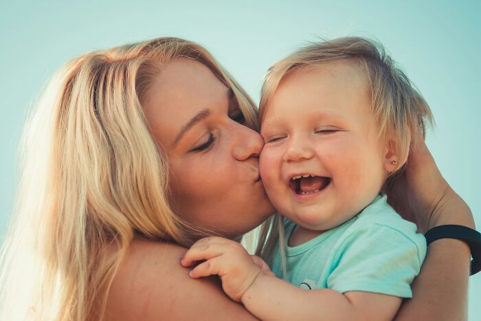 Young woman showing affection to toddler outdoors, highlighting themes of daughter-in-law and racist mother-in-law conflict.